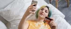 minorenne che si fa un selfie con una carta prepagata in mano
